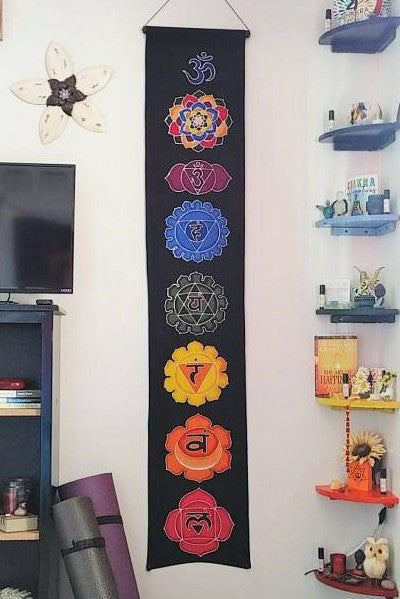 Vertical batik wall hanging with 7 Chakra Symbols in rainbow of colors on black background. Ethically hand made on 100% rayon fabric.