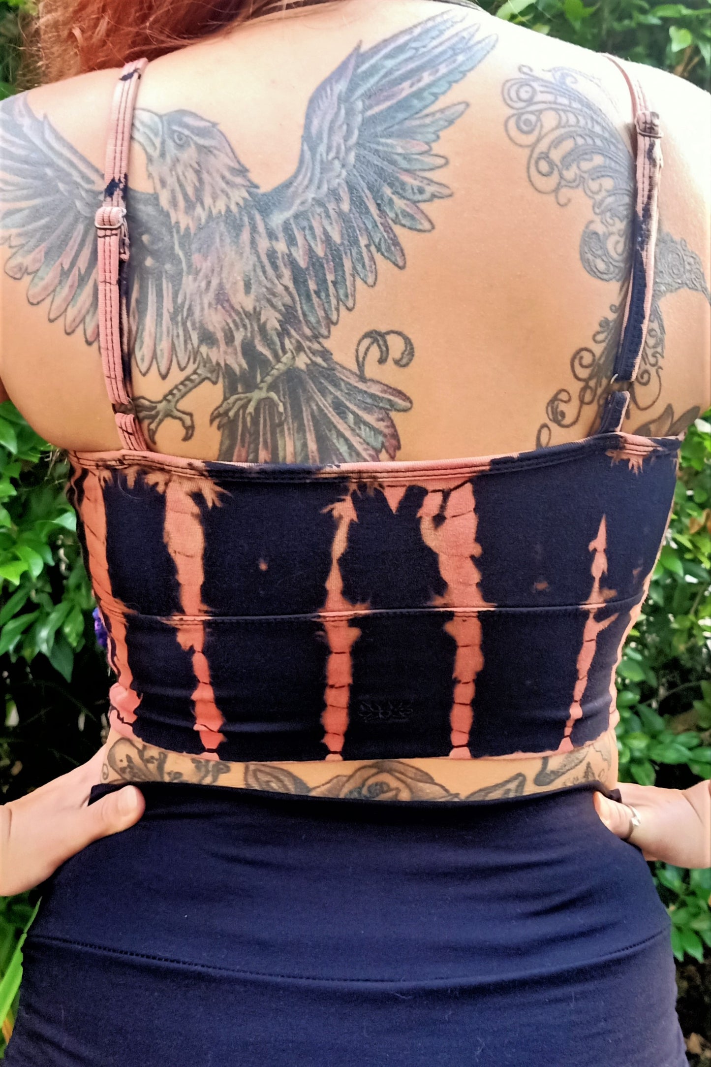Back view of Fire tie dye Blissed Out Crop with spaghetti straps and small lotus flower embroidery detail in center.