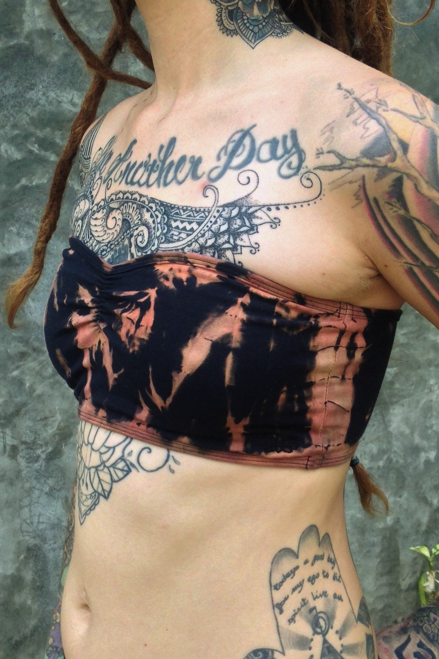 Side view of Fire Tie Dye Bandeau with puckering in the middle and Lotus Flower embroidery on the side. Black with burnt orange tie dye. Made of 90% Organic Cotton with 10% spandex.