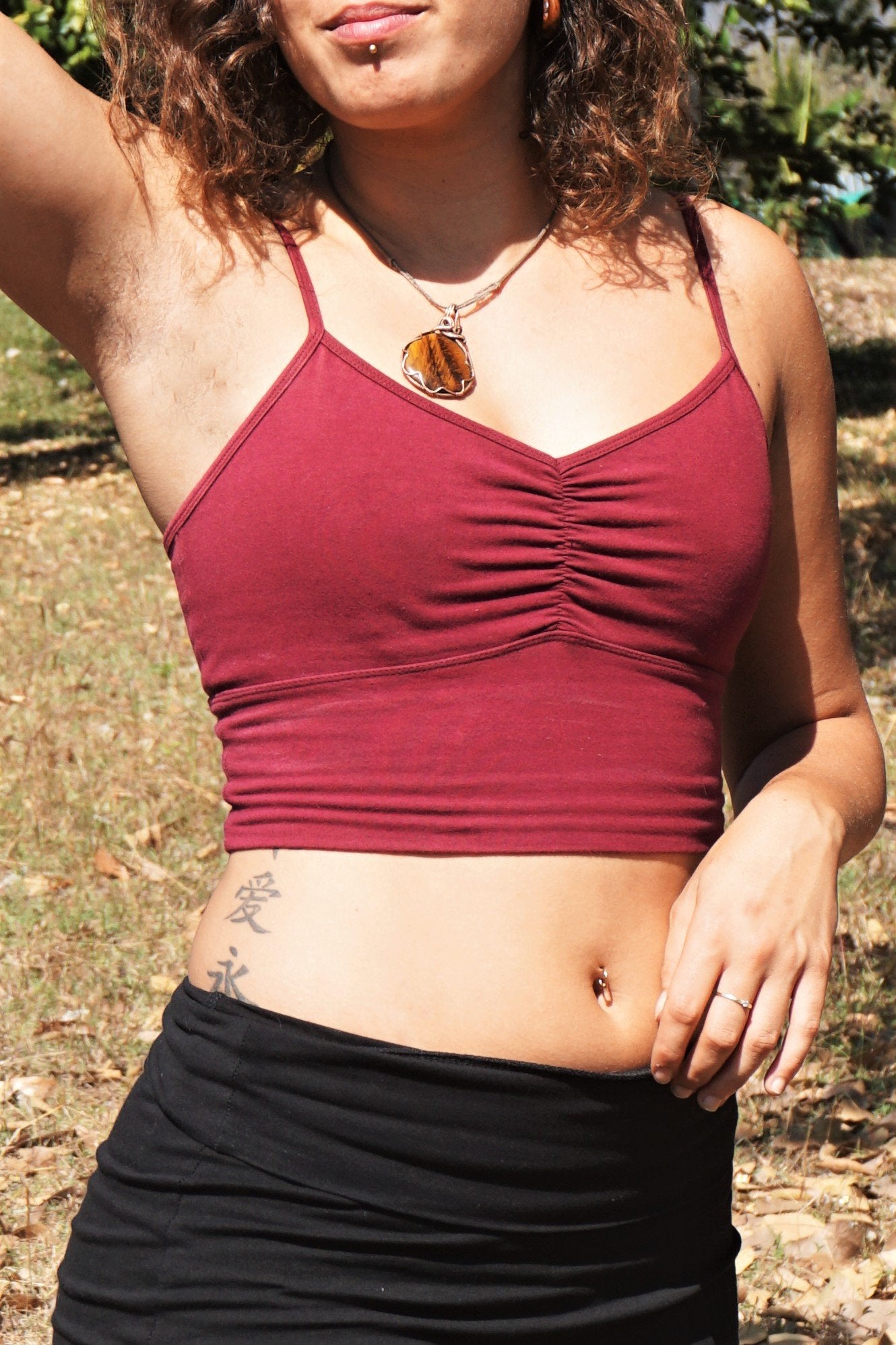 Front view of organic cotton crop tank with adjustable spaghetti straps and scrunched center puckering between the breasts in solid Garnet color.