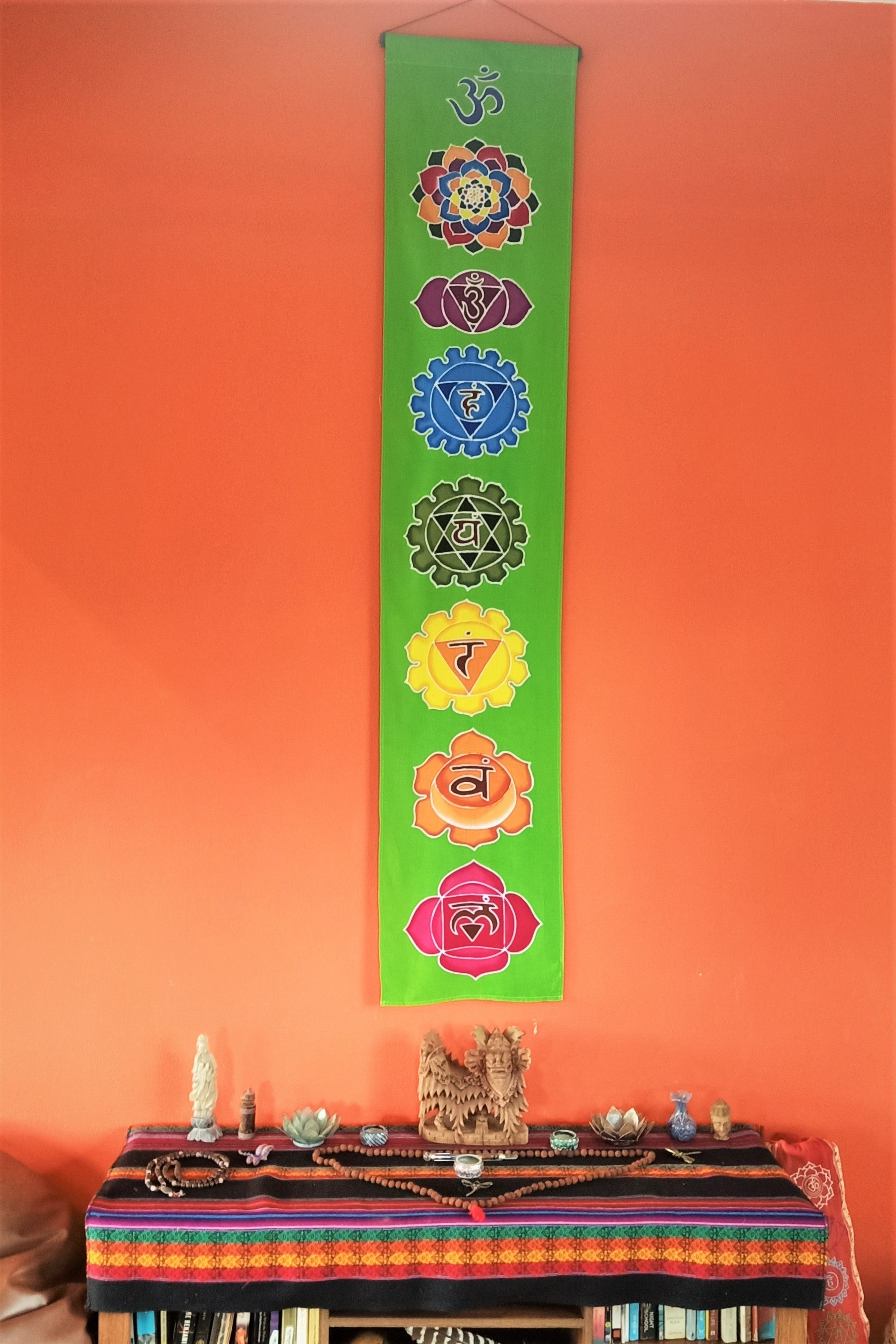 Vertical wall art with neon green background and 7 rainbow chakra symbols. Handmade wax and dye batik art on rayon fabric. Comes ready to hang.
