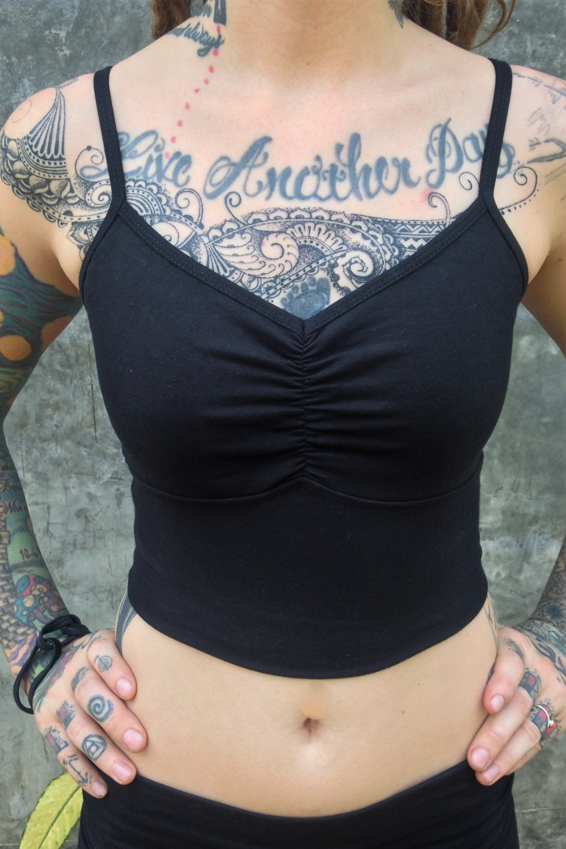 Front view of Organic Blissed Out Crop Tank in black Onyx with adjustable spaghetti straps and scrunched center puckering between the breasts by Lotus Tribe Clothing.