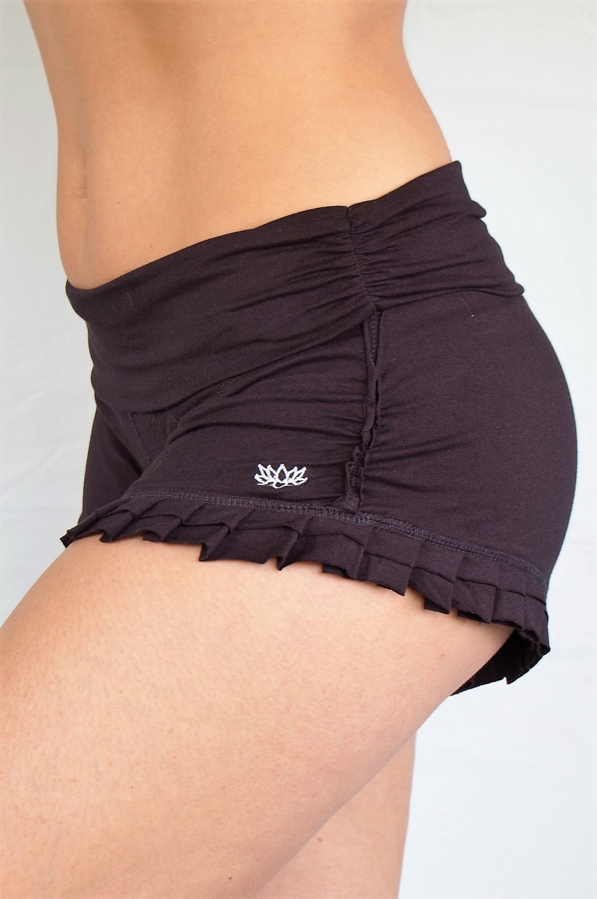 Soft, black short shorts with ruffles at bottom and fold over waist perfect for hot yoga or paired with your favorite top, also great for under a short dress.