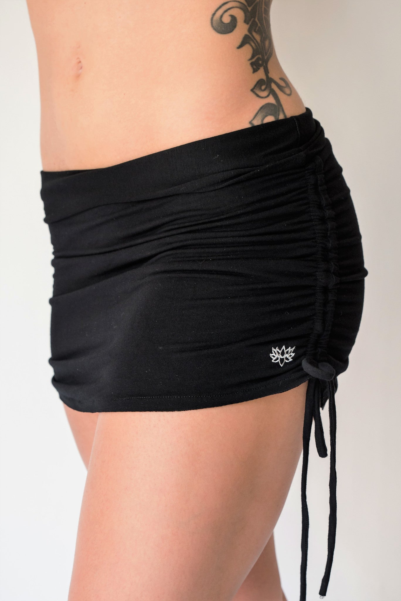 Cute little black mini skirt with pull strings on the sides and fold over waist for adjustable fit. Soft and comfortable 90% rayon 10% cotton. Fits small/medium