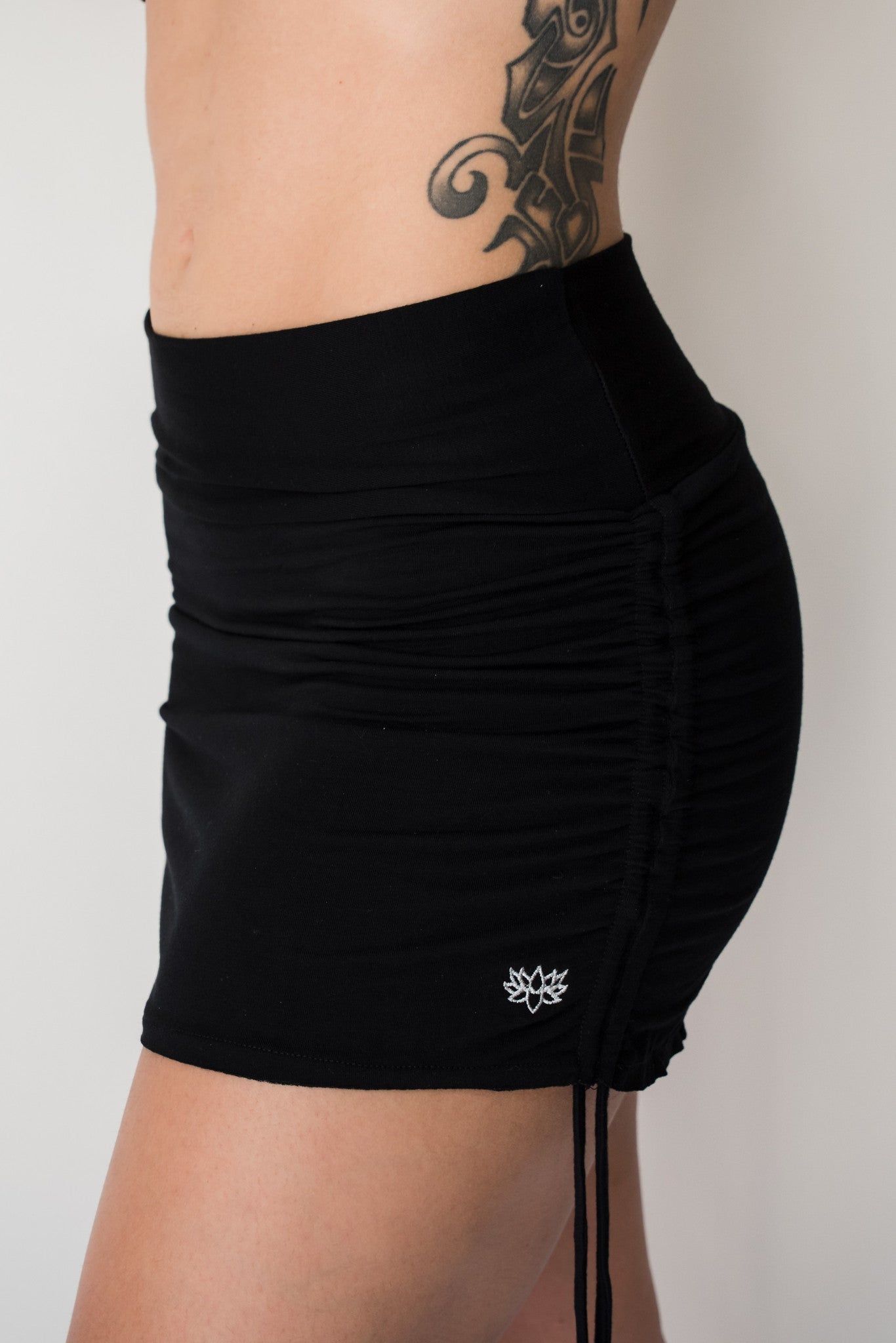 Cute little black mini skirt with pull strings on the sides and fold over waist for adjustable fit. Soft and comfortable 90% rayon 10% cotton. Fits small/medium