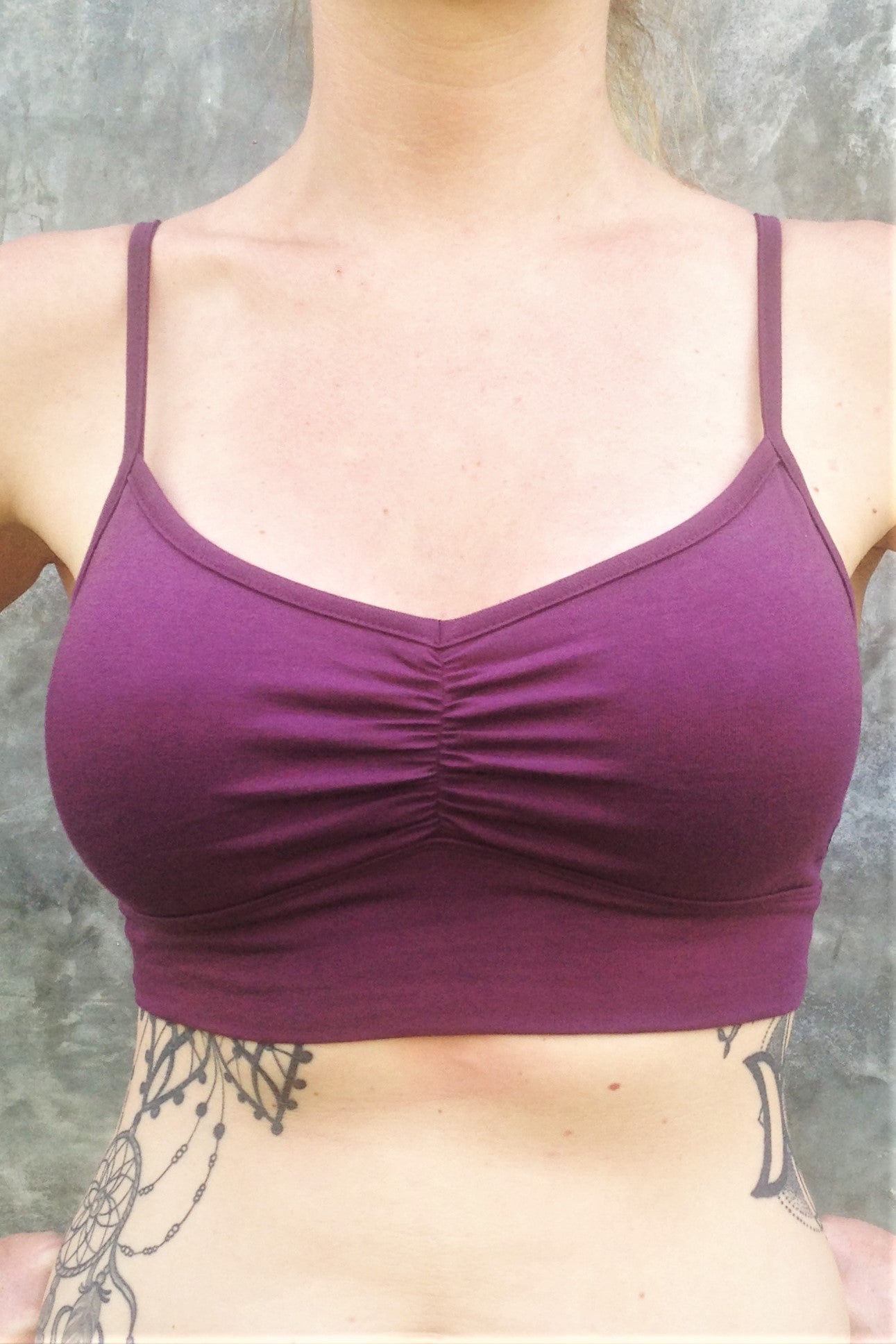 Front view of flattering purple bra with adjustable spaghetti straps and ruched center puckering.