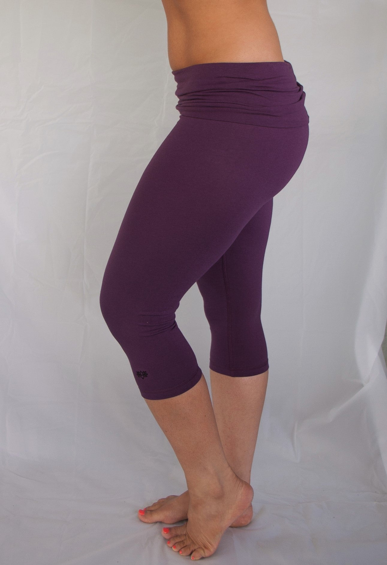 Solid colored plum 3/4 length Yoga Pants have a fold over waist that is adjustable to fit a longer torso or be worn lower on the hips. Soft 90% cotton and 10% spandex.