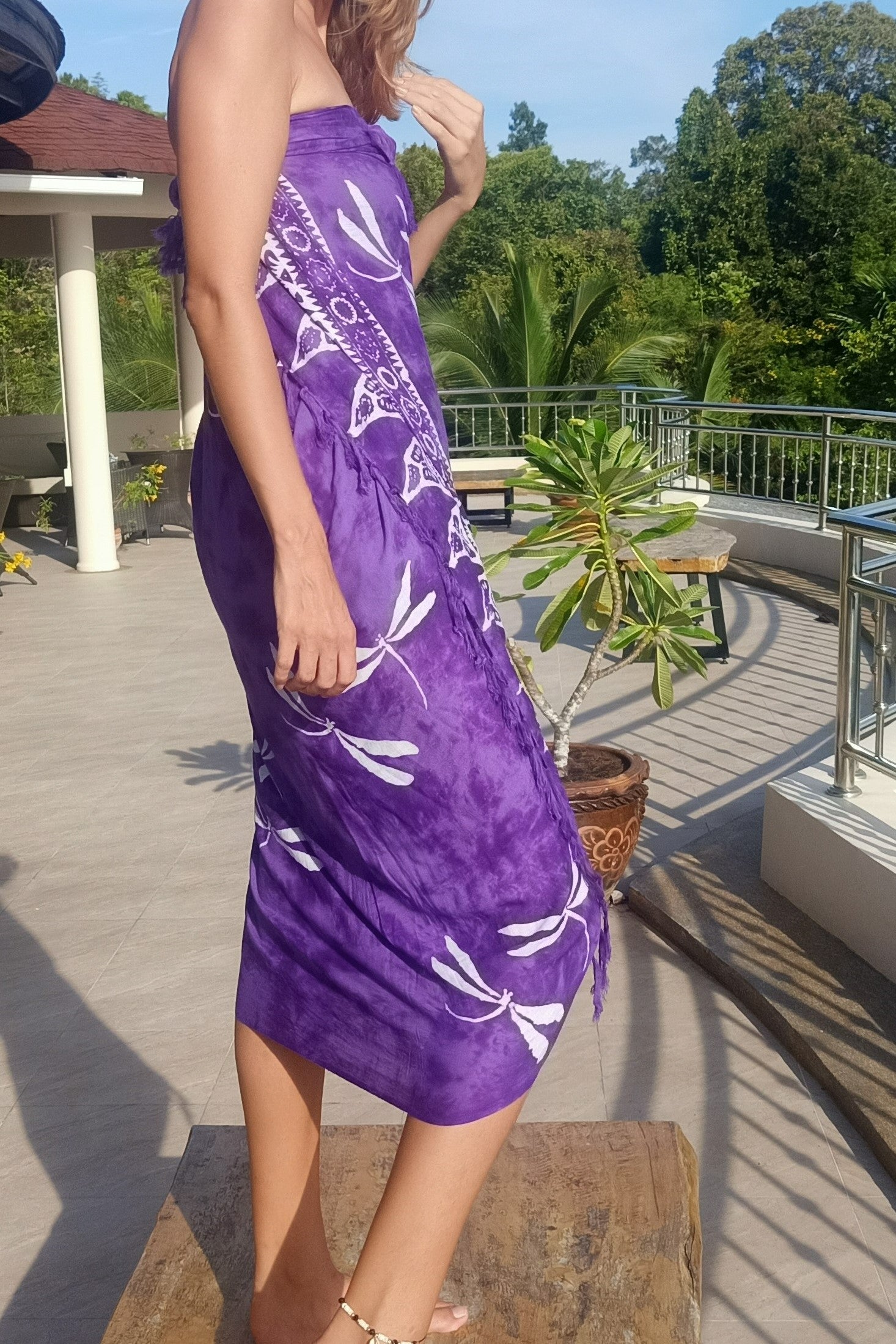 Purple sarong worn as wrap around dress with white dragonfly pattern.