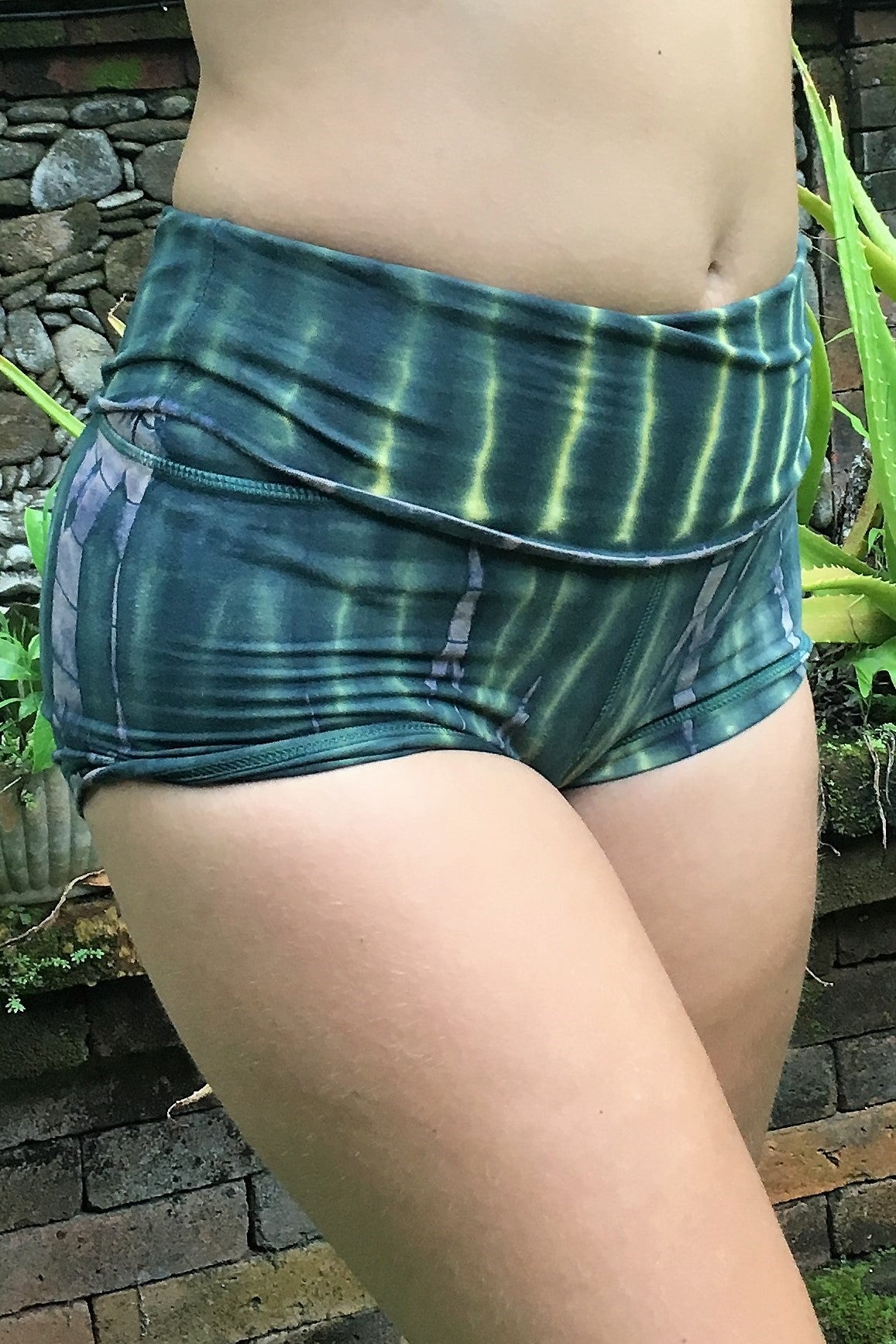 Side view of organic cotton RainForest tie dye yoga Shorts by Lotus Tribe Clothing. Green hues with beige highlights.