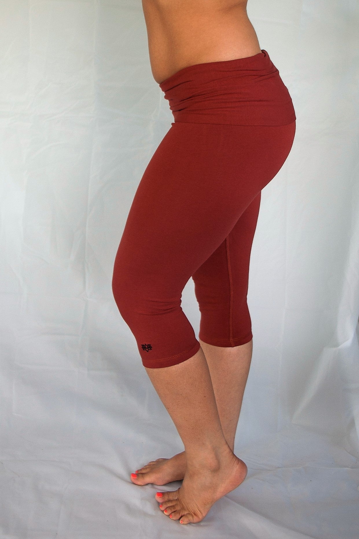 Rust solid colored rust 3/4 length Yoga Pants have a fold over waist that is adjustable to fit a longer torso or be worn lower on the hips. Soft 90% cotton and 10% spandex.