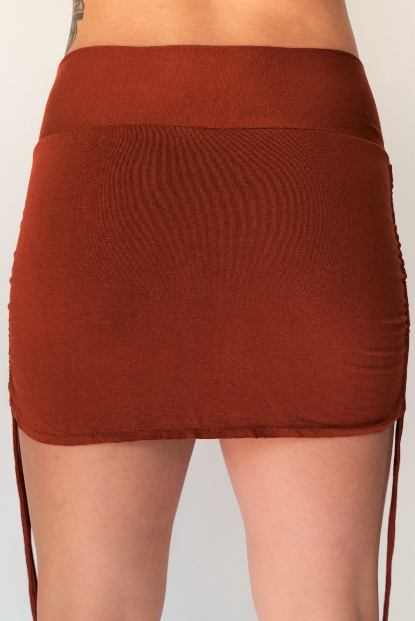 Cute little rust colored mini skirt with pull strings on the sides and fold over waist for adjustable fit. Soft and comfortable 90% rayon 10% cotton. Fits S/M