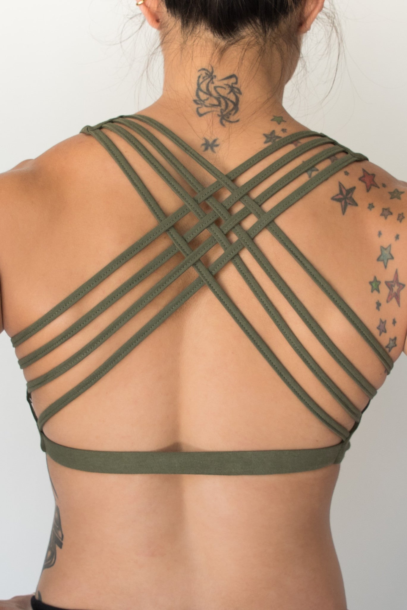 Sage sports bra with silver bodhi tree design on front, has 4 criss cross straps on back with enough support for down dog or other yoga poses.