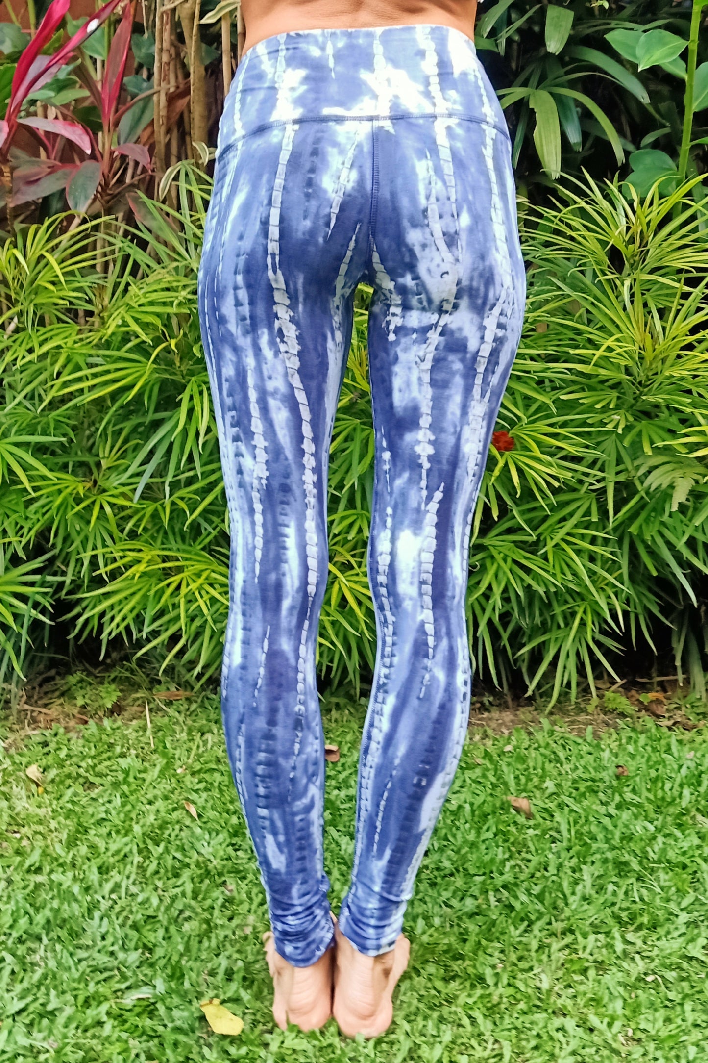 Back view of the Wildflower tie dye Yoga Pants by Lotus Tribe shows the streaked vertical pattern of the tie dye. Colors a blues and purple tones with grey and white streaks and highlights.