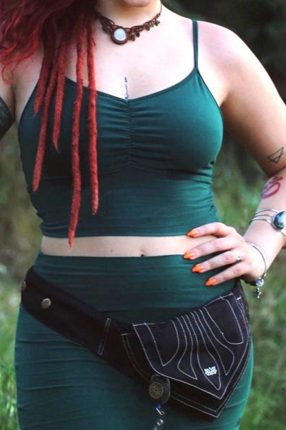 woman wearing black pocket belt, hanging low on the hips with lotus flower embroidery over Forest green outfit all by Lotus Tribe Clothing