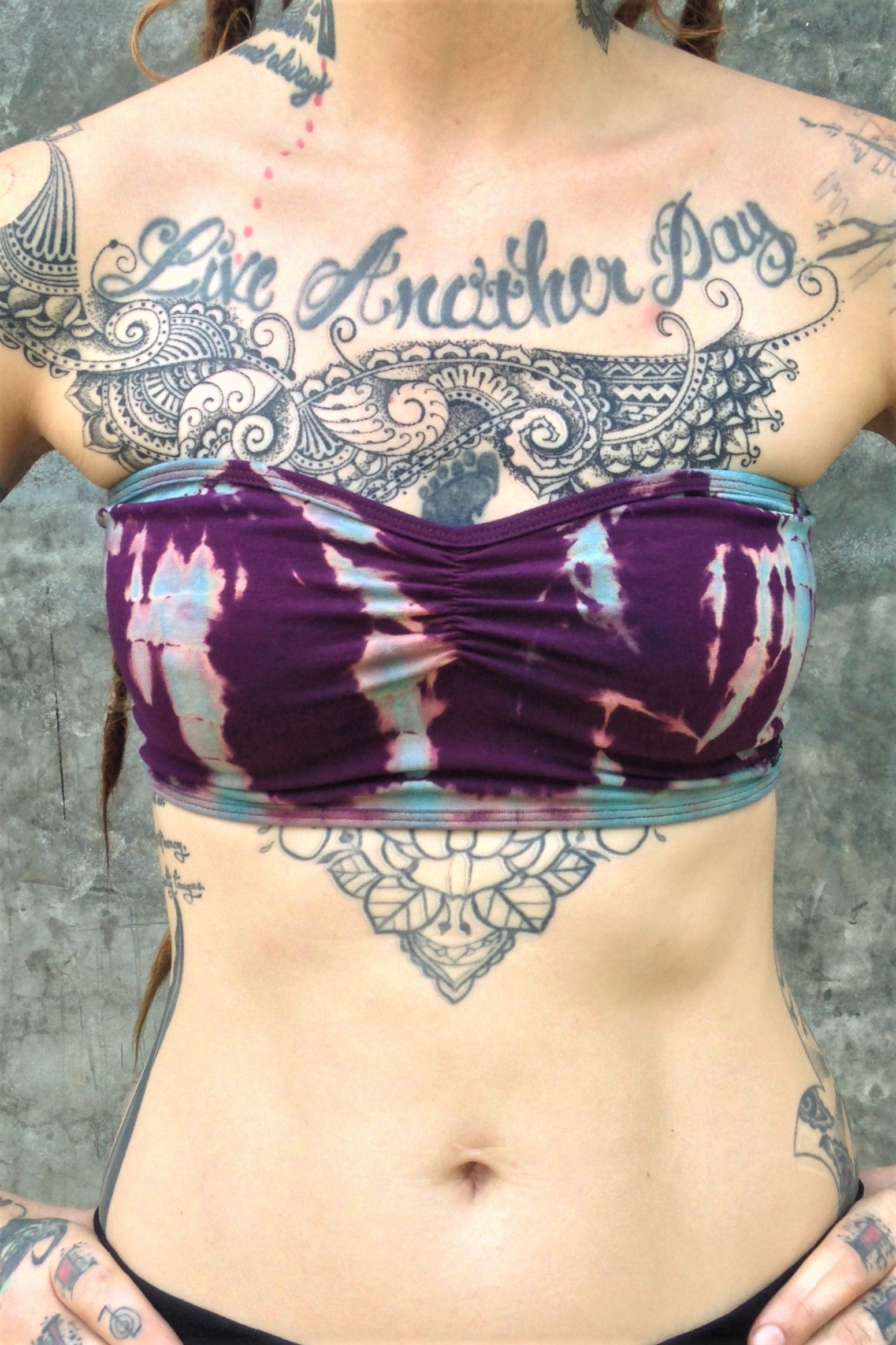 Front view of Amethyst Tie Dye Bandeau with center puckering between the breast. Tie dyed purple with blue steaks made form 90% Organic Cotton with 10% spandex. 