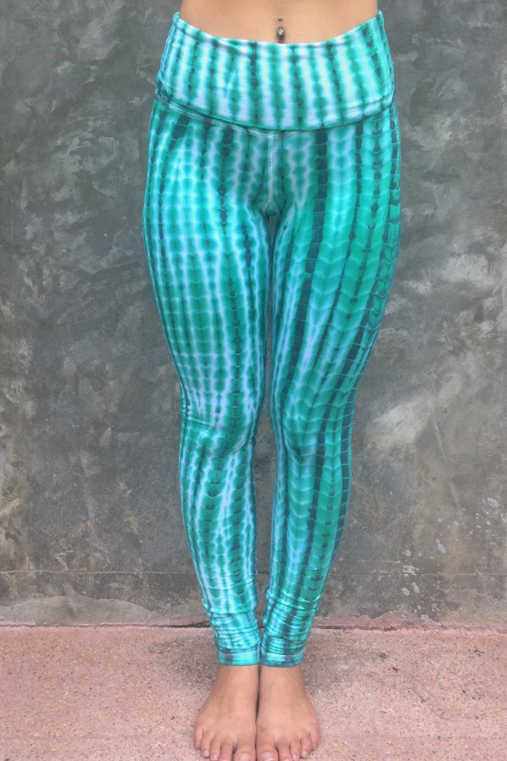 Long length yoga pants turquoise/teal tie dye. Fold over top for adjustable fit can be worn with higher waist or lower on the hips. 90% cotton 10% spandex. front view