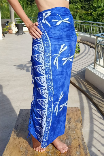 Rayon sarong ethically hand made by hand. Blue background with white dragonfly pattern batik. Shown as wrap around skirt.