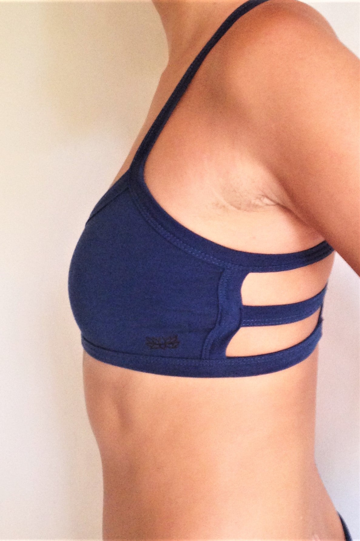 Side view of one of the most comfortable sports bras you will ever wear, soft and super cute. Solid Cobalt blue front with 3 horizontal straps across back. Medium support.