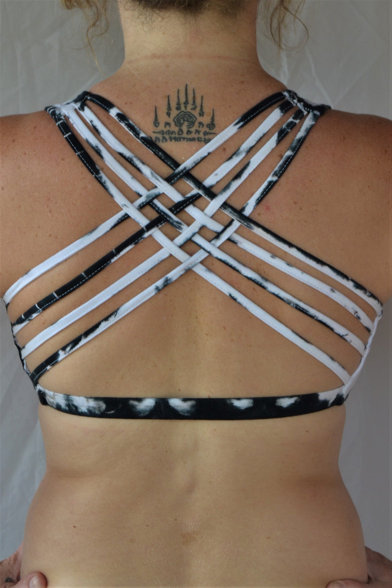 Soft, comfortable and super cute black and white tie dyed sports bra with criss cross straps on back.