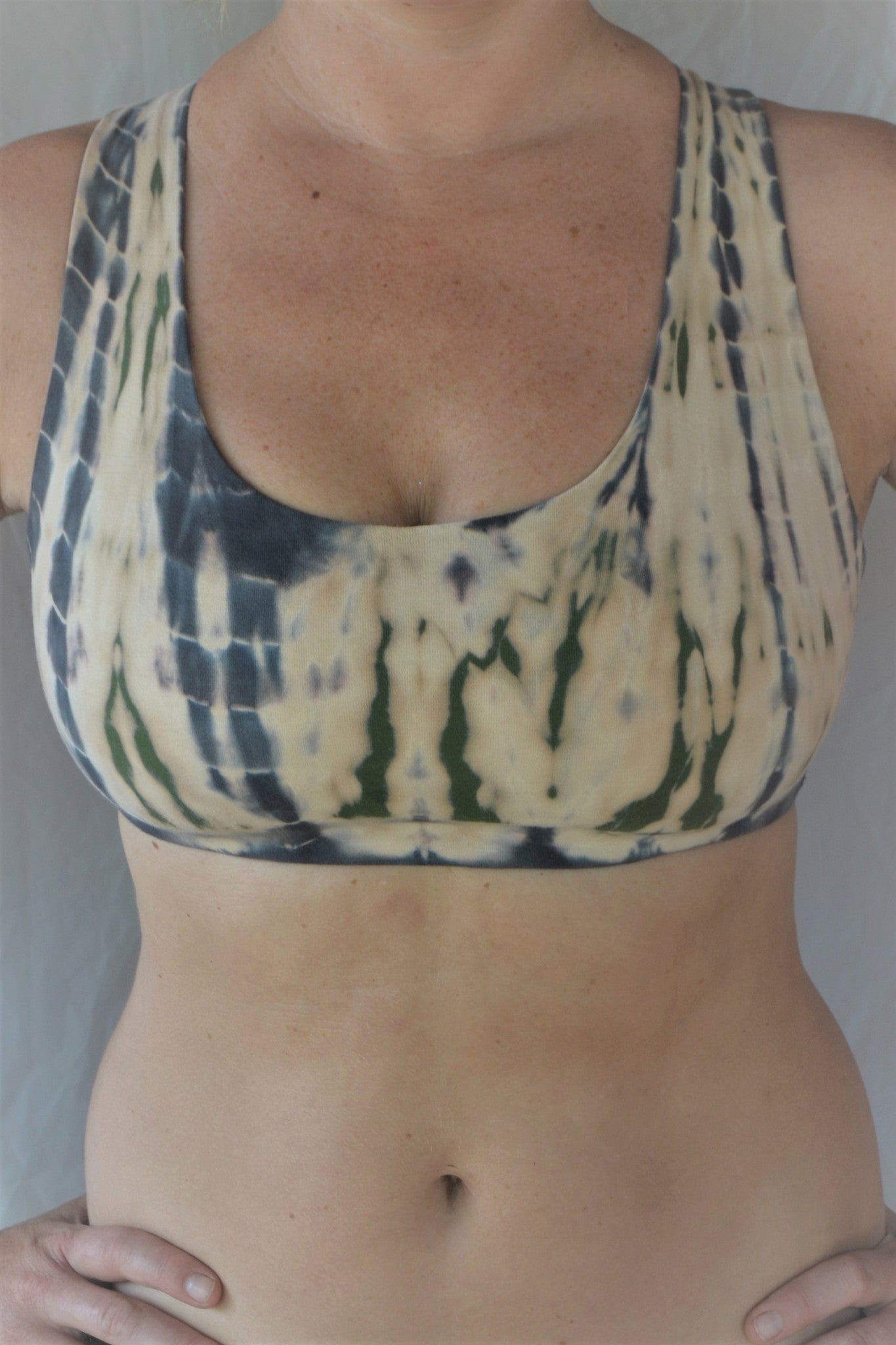 Soft, comfortable and super cute sports bra in peachy pink tie dye with green and grey highlights.