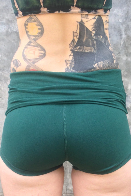 Back view of Forest green yoga shorts with fold over waist, can be worn higher waisted, or low on the hips. 90% cotton 10% spandex.