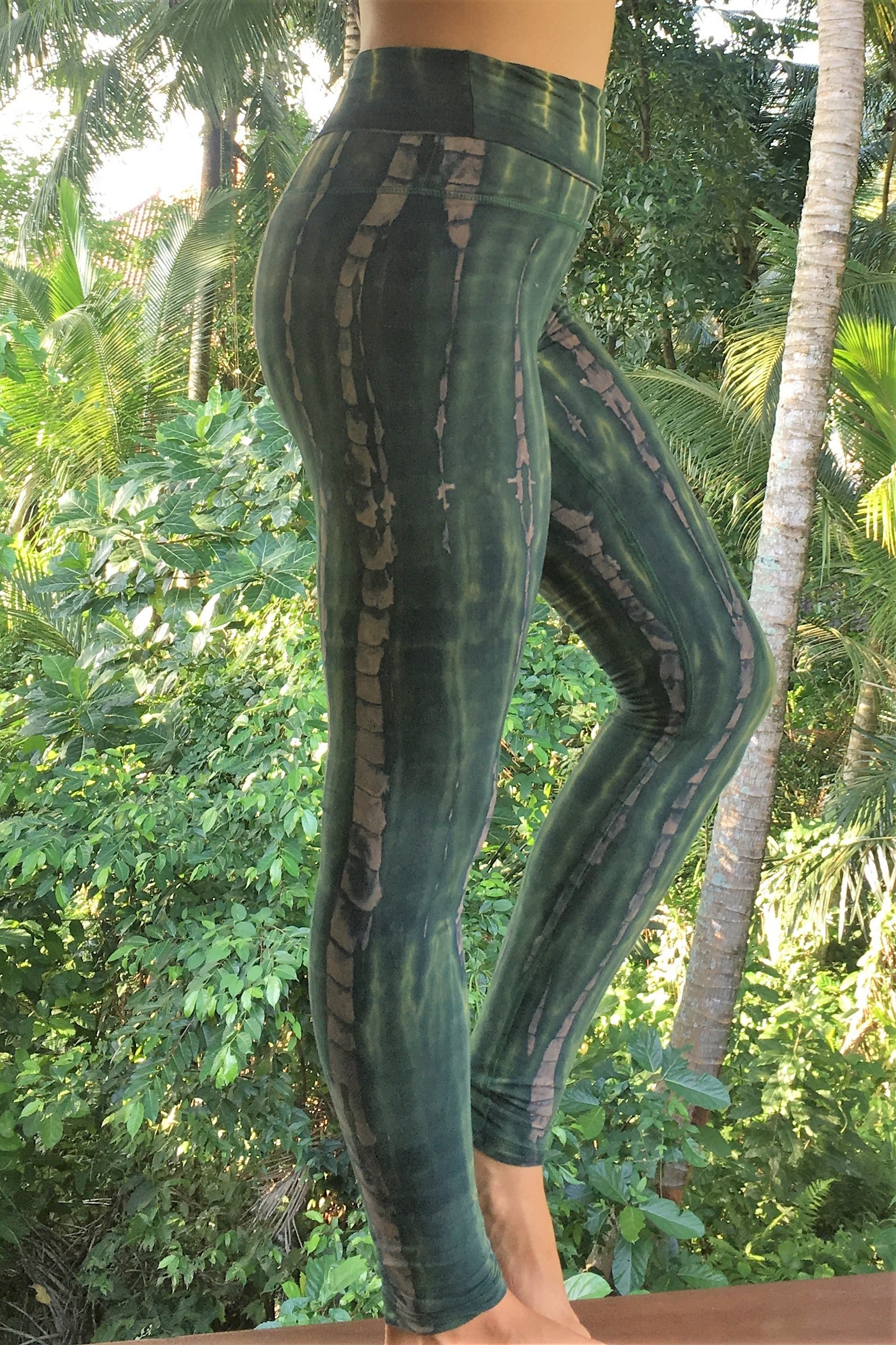 Side view of Organic Yoga Pants in RainForest tie dye with fold waist top can be worn high or folded down onto hips for custom fit. Green hues with beige streaks. 