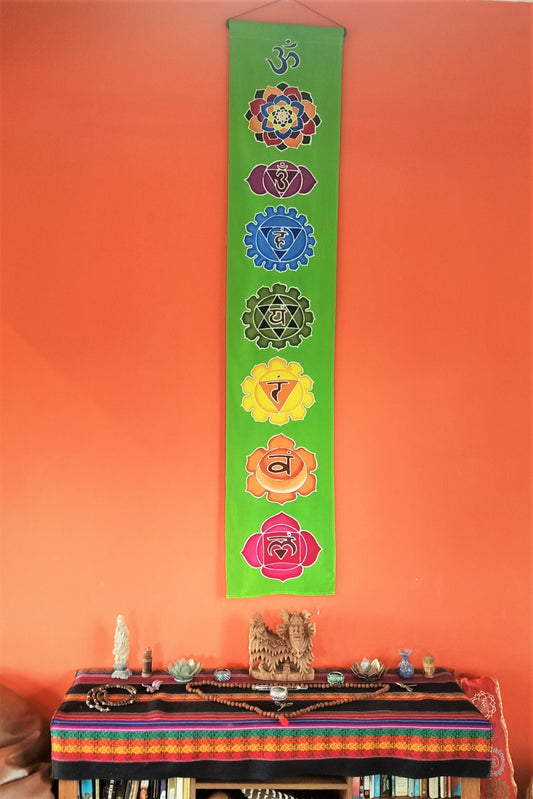 Vertical wall art with neon green background and 7 rainbow chakra symbols. Handmade wax and dye batik art on rayon fabric. Comes ready to hang.