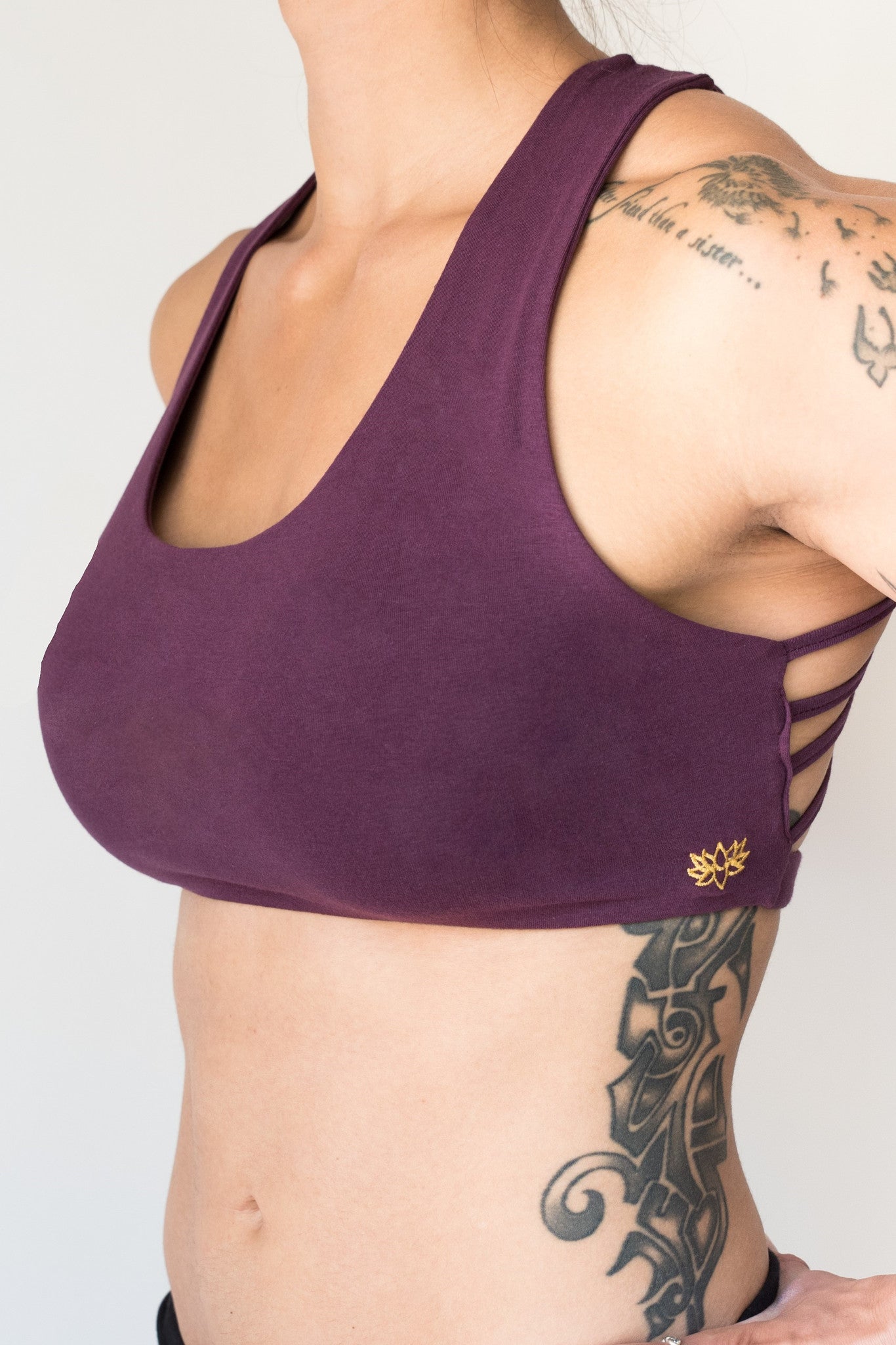 Plum colored sports bra that has 4 criss cross straps in back and has enough support for down dog and other yoga poses. 90% cotton 10% spandex 