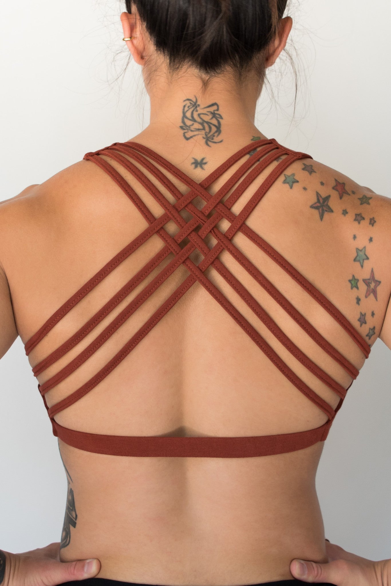 Rust sports bra with 4 criss cross straps on back with enough support for down dog and other yoga poses, or whatever sports you enjoy. 90% cotton 10% spandex 