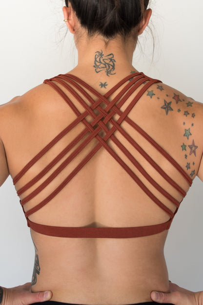 Rust sports bra with 4 criss cross straps on back with enough support for down dog and other yoga poses, or whatever sports you enjoy. 90% cotton 10% spandex 