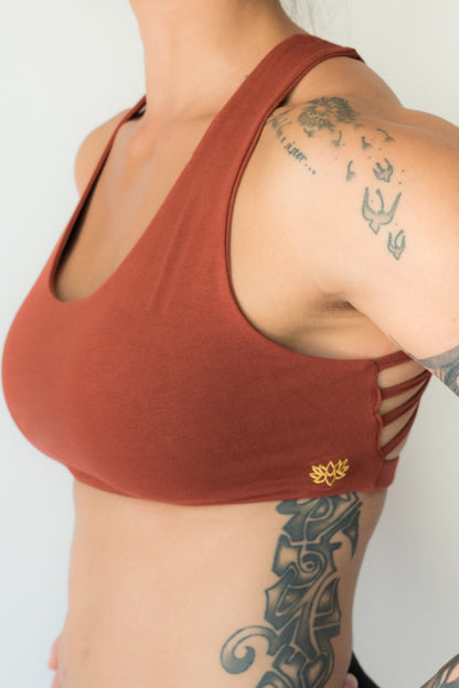 Rust sports bra with 4 criss cross straps on back with enough support for down dog and other yoga poses, or whatever sports you enjoy. 90% cotton 10% spandex 