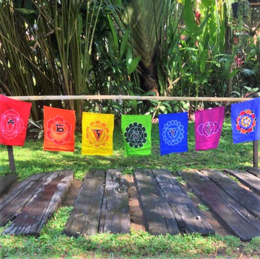 Handmade batik Chakra Flags 7 piece set. Each flag has one chakra in a rainbow of colors. Comes ready to hang on string. Rayon fabric. 